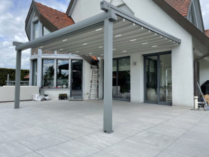 Pergola retractable alsace fixer au mur sur une terrasse dalle