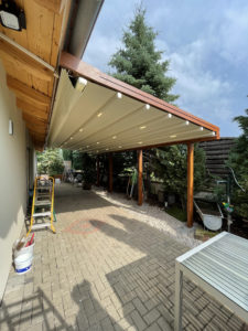 Pergola retractable alsace fixer au mur sur une terrasse avec un aspect corten